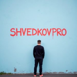 ИП Шведков И.А. молча пишет на стене красной краской: «ShvedkovPRO», минималистичный кадр, холодная цветовая гамма